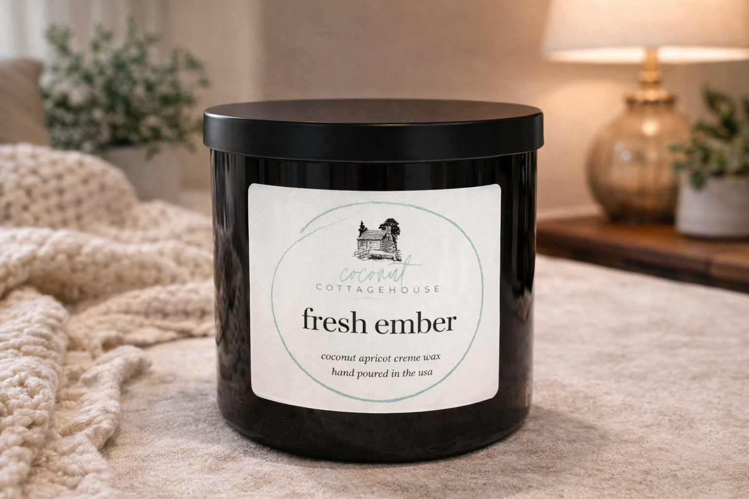 A black candle jar with a label that reads "fresh ember" and "coconut apricot crème wax hand poured in the USA".